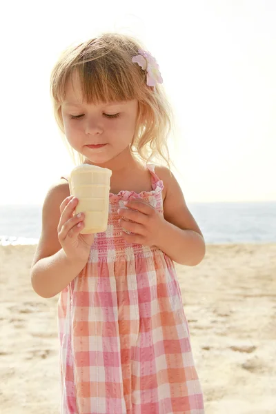 Ребенок с мороженым на море — стоковое фото