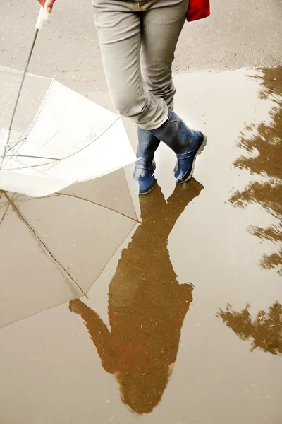 Ένας άνθρωπος με μια ομπρέλα του μπότες στη λακκούβα — Φωτογραφία Αρχείου