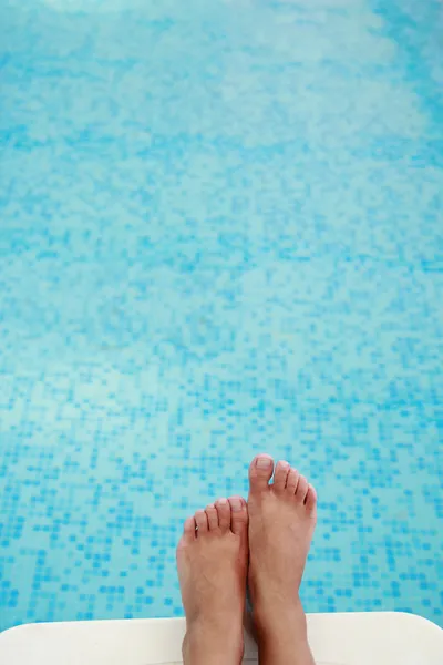 Vrouwelijke benen in het zwembad water — Stockfoto