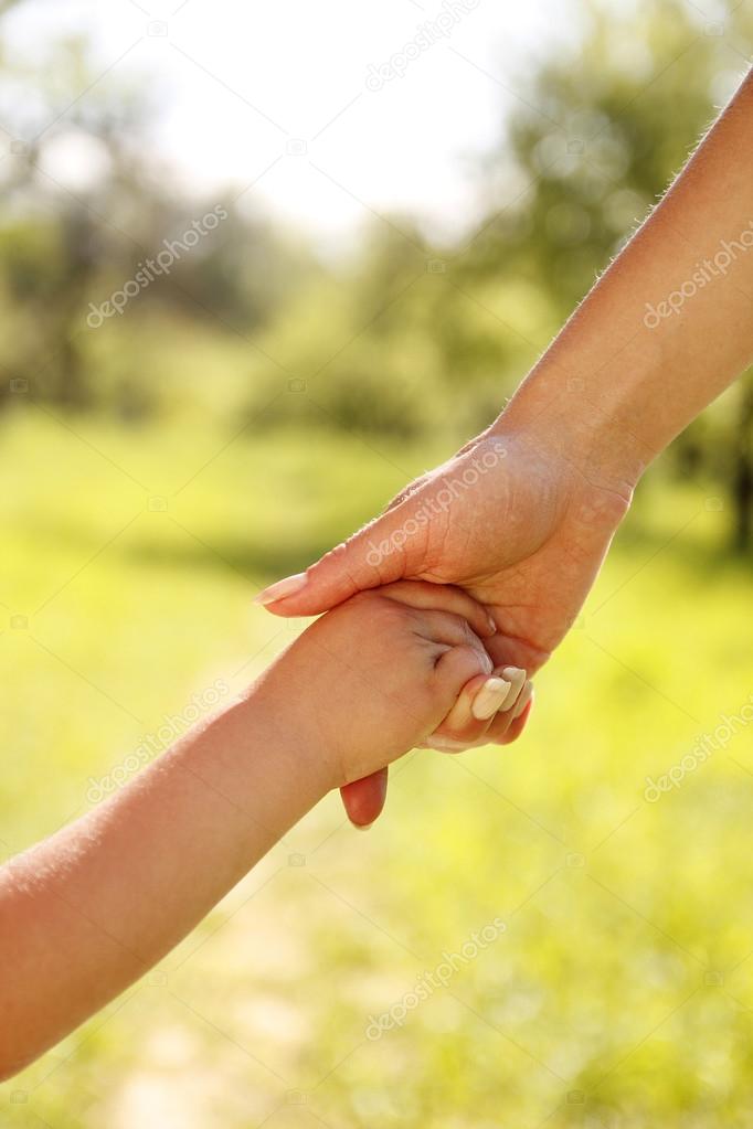 parent holds the hand of a child