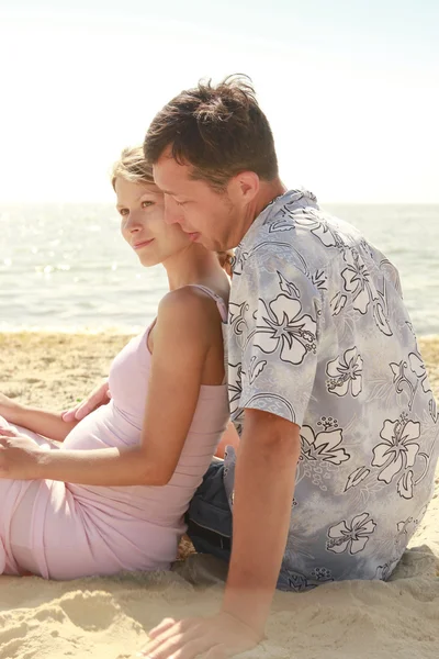 Pregnant couple in love on the beach — Stock Photo, Image