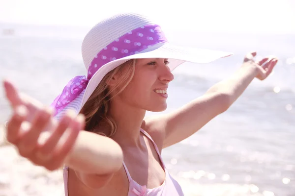 Chica feliz con un sombrero en una playa — Foto de Stock