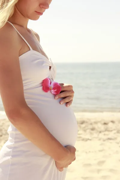 Беременная женщина на пляже — стоковое фото