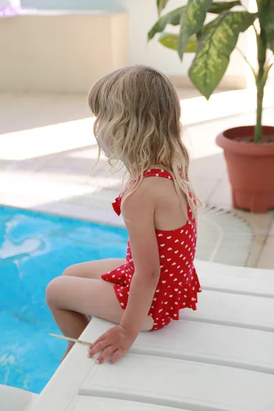 Girl in the water pool on a sun lounger — Stock Photo, Image