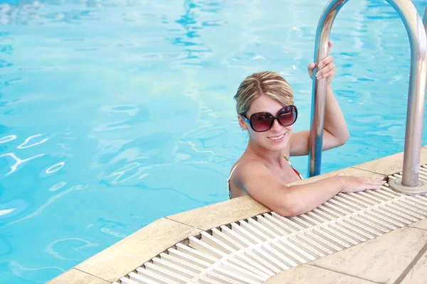 Chica en la piscina de agua en gafas de sol — Foto de Stock