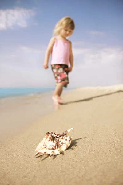 Lille pige leger på havet kysten - Stock-foto