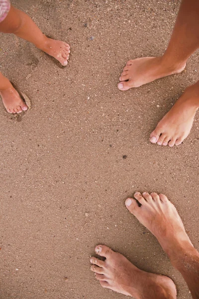 Les pieds de famille dans le sable — Photo