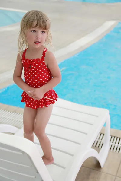 Girl in the water pool on a sun lounger — Stock Photo, Image