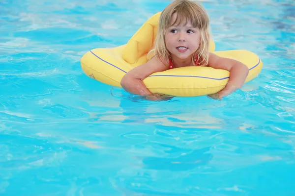 Flicka simmar i en pool med en cirkel — Stockfoto