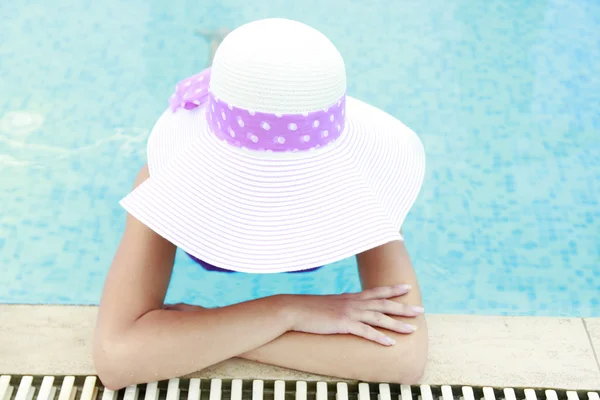 Menina em um chapéu na piscina de água — Fotografia de Stock