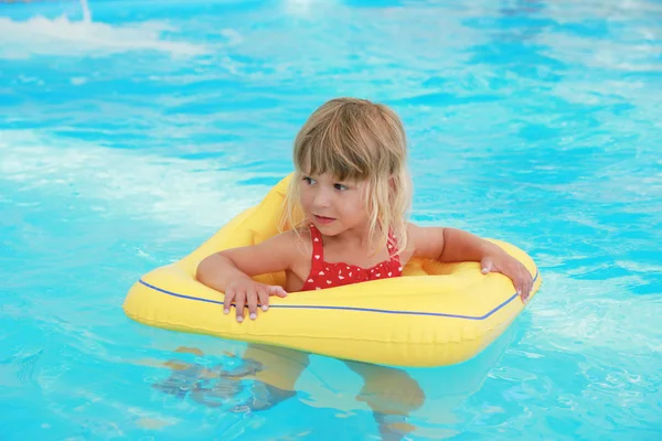 Chica nada en una piscina con un círculo — Foto de Stock