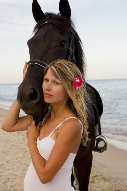 Deniz kenarında bir at ile kız