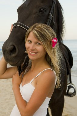 Deniz kenarında bir at ile kız