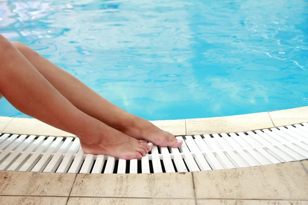 Vrouwelijke benen in het zwembad water — Stockfoto