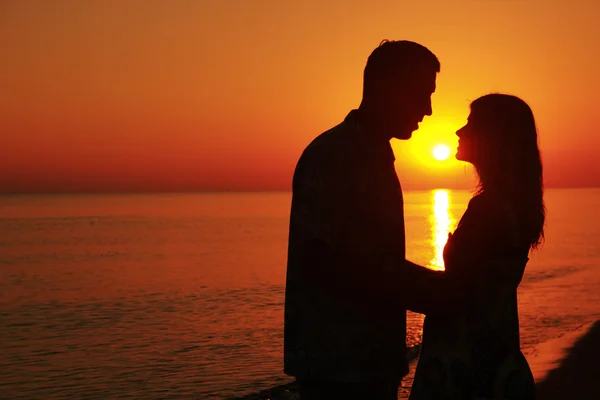 Silhueta de um casal amoroso ao pôr do sol — Fotografia de Stock
