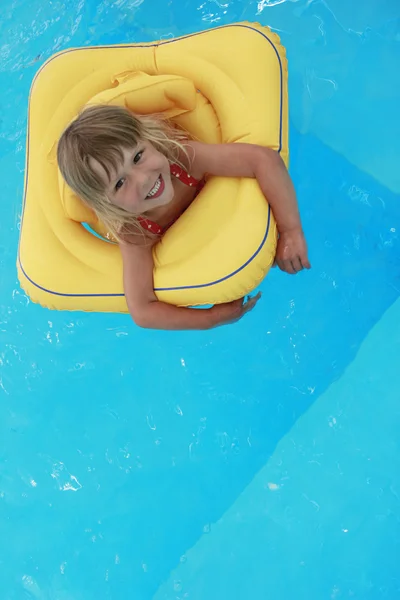 Meisje zwemt in een zwembad met een cirkel — Stockfoto