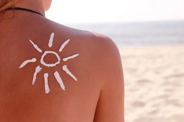 Creme solar na fêmea de volta na praia — Fotografia de Stock