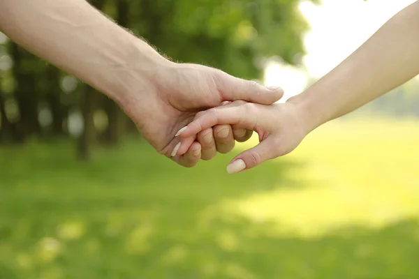 Two hands of a loving couple on nature — Stock Photo, Image