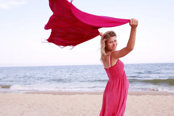 Zwangere vrouw met een sjaal op het strand — Stockfoto