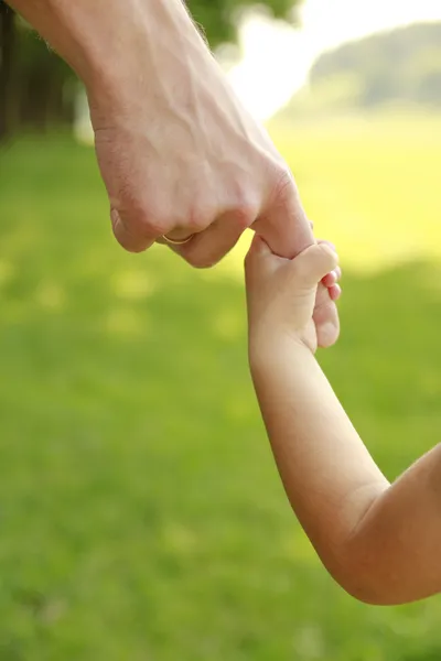 มือของพ่อแม่และลูกในธรรมชาติ — ภาพถ่ายสต็อก