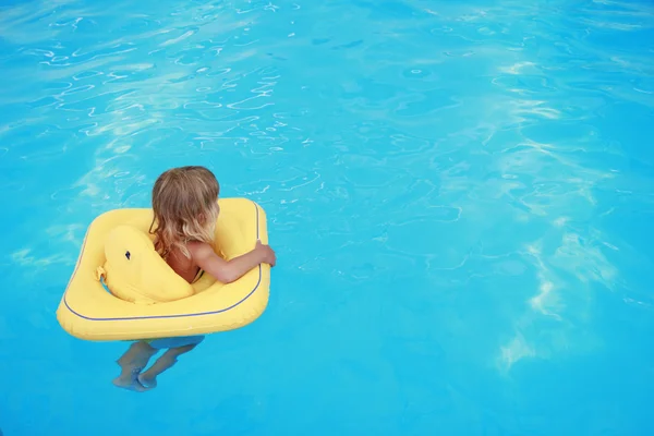 Menina nada em uma piscina com um círculo — Fotografia de Stock
