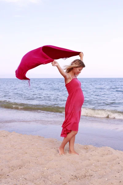 Kobieta w ciąży z szalikiem na plaży — Zdjęcie stockowe