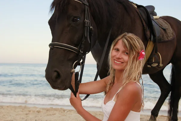 Дівчина з конем біля моря — стокове фото