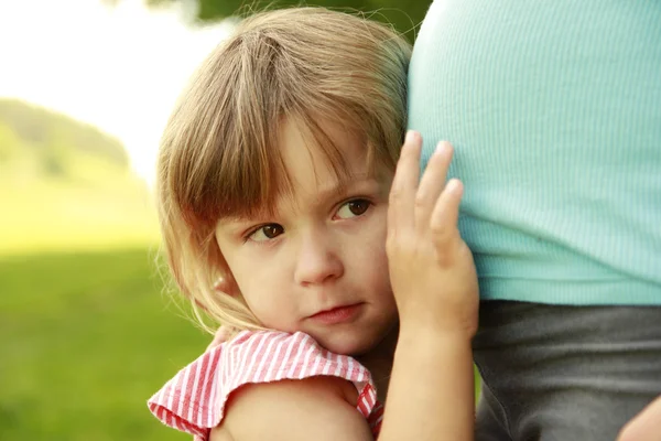 Bambina vicino al ventre di sua madre incinta sulla natura — Foto Stock