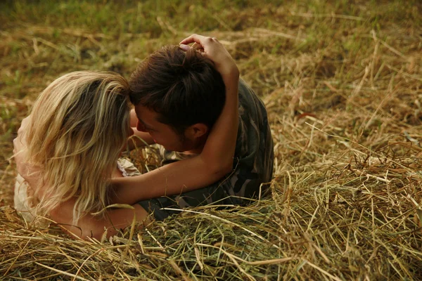 Pareja enamorada en un pajar en la naturaleza — Foto de Stock