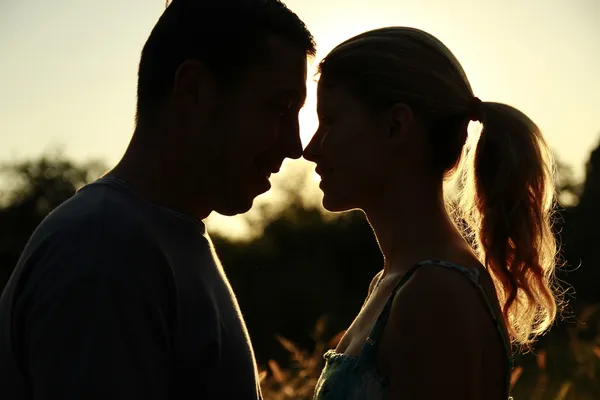 Silhueta de um casal amoroso ao pôr do sol — Fotografia de Stock