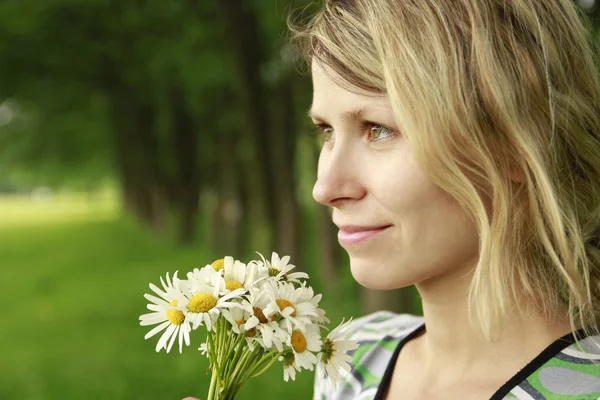 Ung pige med en buket blomster i naturen - Stock-foto
