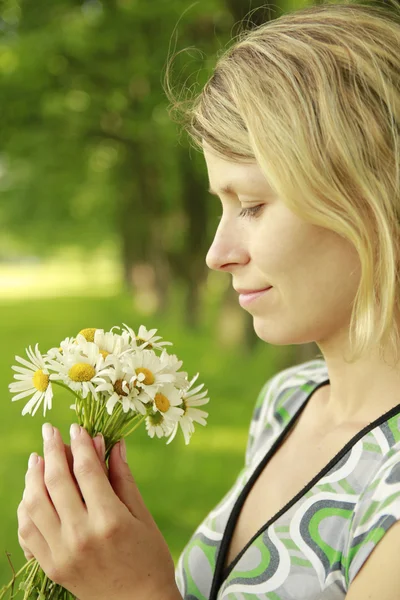 干し草の近くの自然の花の花束を持つ少女 — ストック写真