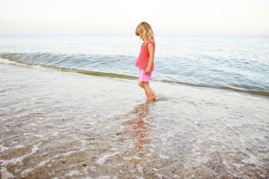 Deniz kıyısında oynayan küçük kız