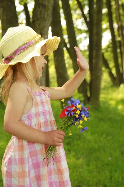 Linda menina com um buquê de flores na natureza — Fotografia de Stock