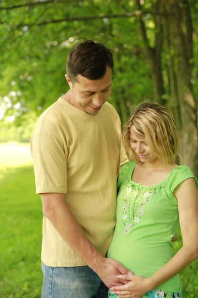 Um jovem casal grávida na natureza — Fotografia de Stock