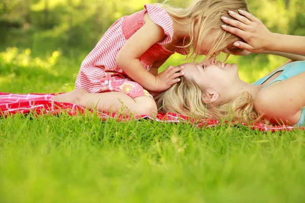 Mama och hennes lilla dotter spela på gräs — Stockfoto