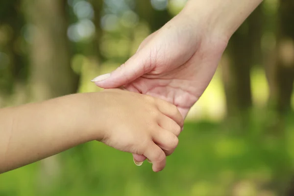 Eltern halten die Hand eines kleinen Kindes — Stockfoto