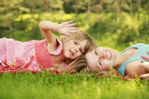 ママと彼女の小さな娘、芝生で遊んで — ストック写真