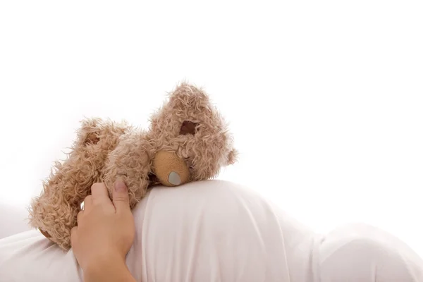 A pregnant woman with a teddy bear on a white background — Stock Photo, Image