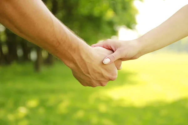 Two hands of a loving couple on nature — Stock Photo, Image