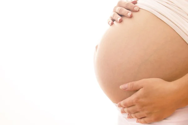 La donna incinta su uno sfondo bianco — Foto Stock