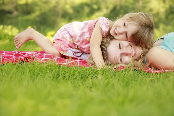 Mama and her little daughter playing on grass — Stock Photo, Image