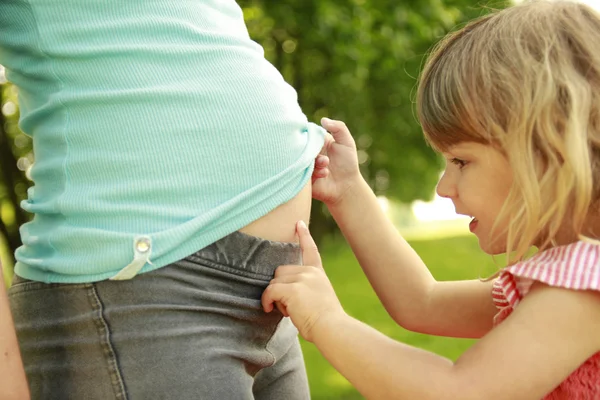 ผู้หญิงท้องสาวและลูกสาวตัวน้อยของเธอบนธรรมชาติ — ภาพถ่ายสต็อก