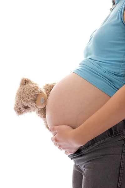 Μια έγκυος γυναίκα με ένα αρκουδάκι σε λευκό φόντο — Φωτογραφία Αρχείου