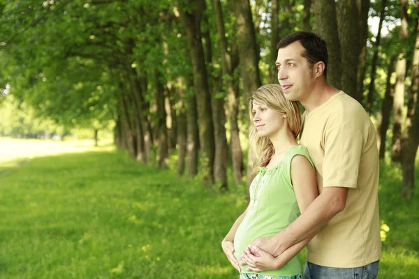 Un jeune couple enceinte sur la nature — Photo