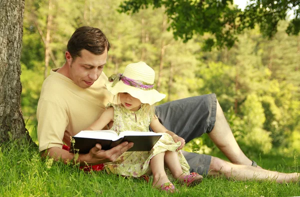 Genç baba küçük kızı ile İncil okur — Stok fotoğraf