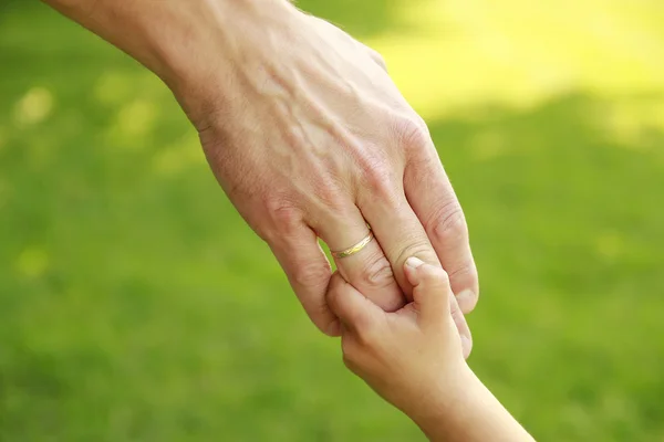 Eltern halten die Hand eines kleinen Kindes — Stockfoto