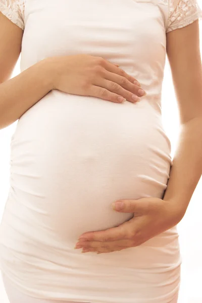 A mulher grávida em um fundo branco — Fotografia de Stock