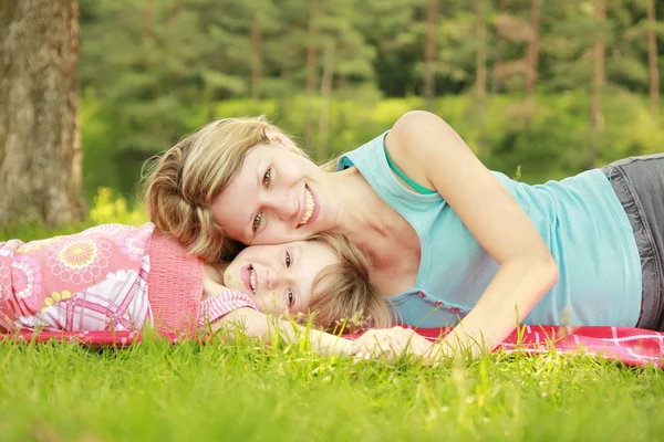 Jonge moeder en haar dochtertje spelen op gras — Stockfoto