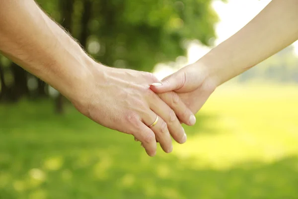 Two hands of a loving couple on nature — Stock Photo, Image
